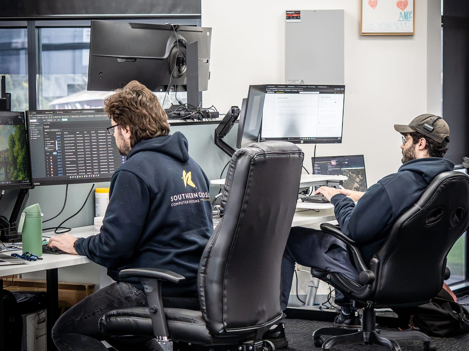 SCCS engineers working across large monitors at the service desk