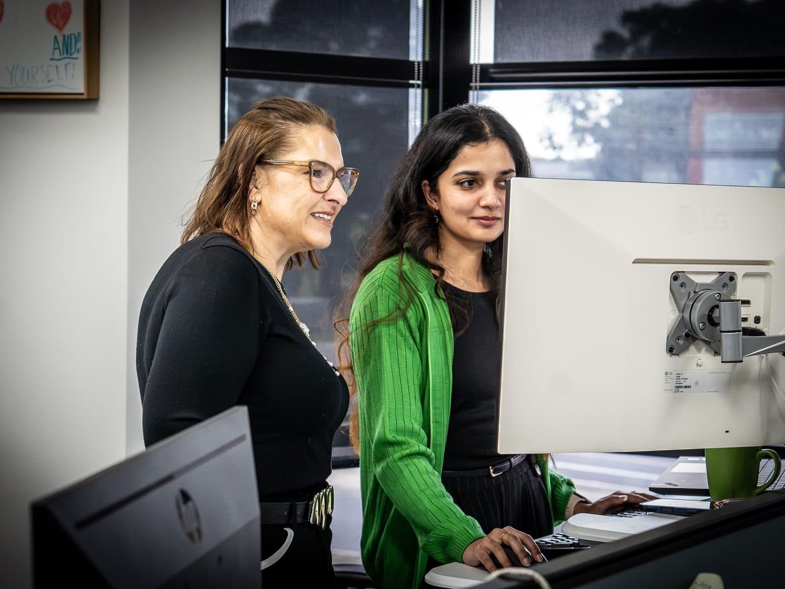 Two SCCS team members reviewing a system together at a workstation