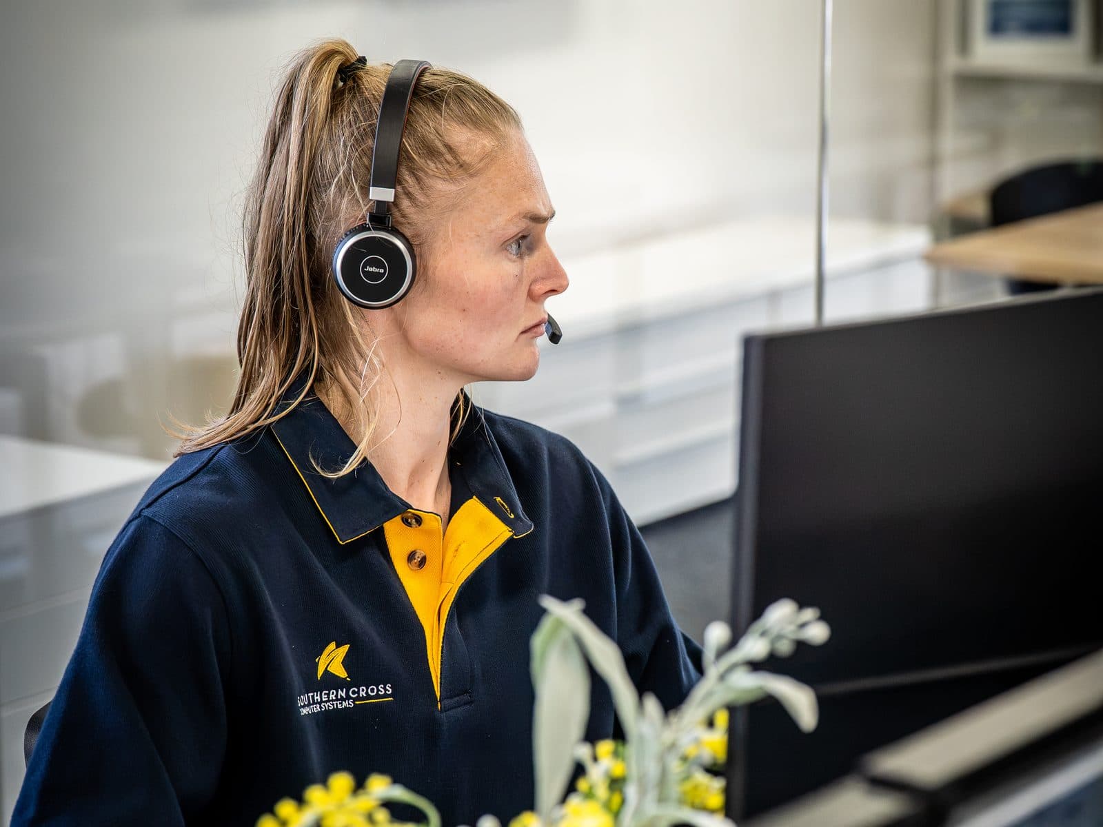 An SCCS support specialist wearing a headset, mid call